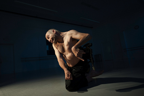 dancer Neil Marcus with naked upper body, tense pose