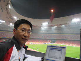Dong Seok Kim keeps an eye on the action inside the Bird's Nest. Dong Seok Kim keeps an eye on the action inside the Bird's Nest.