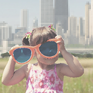 photo of a toddler playing with oversized eyeglasses
