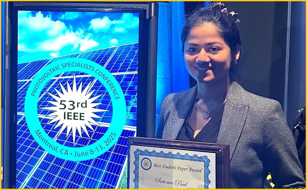 A photograph of Sritoma Paul posed with an award next to a podium